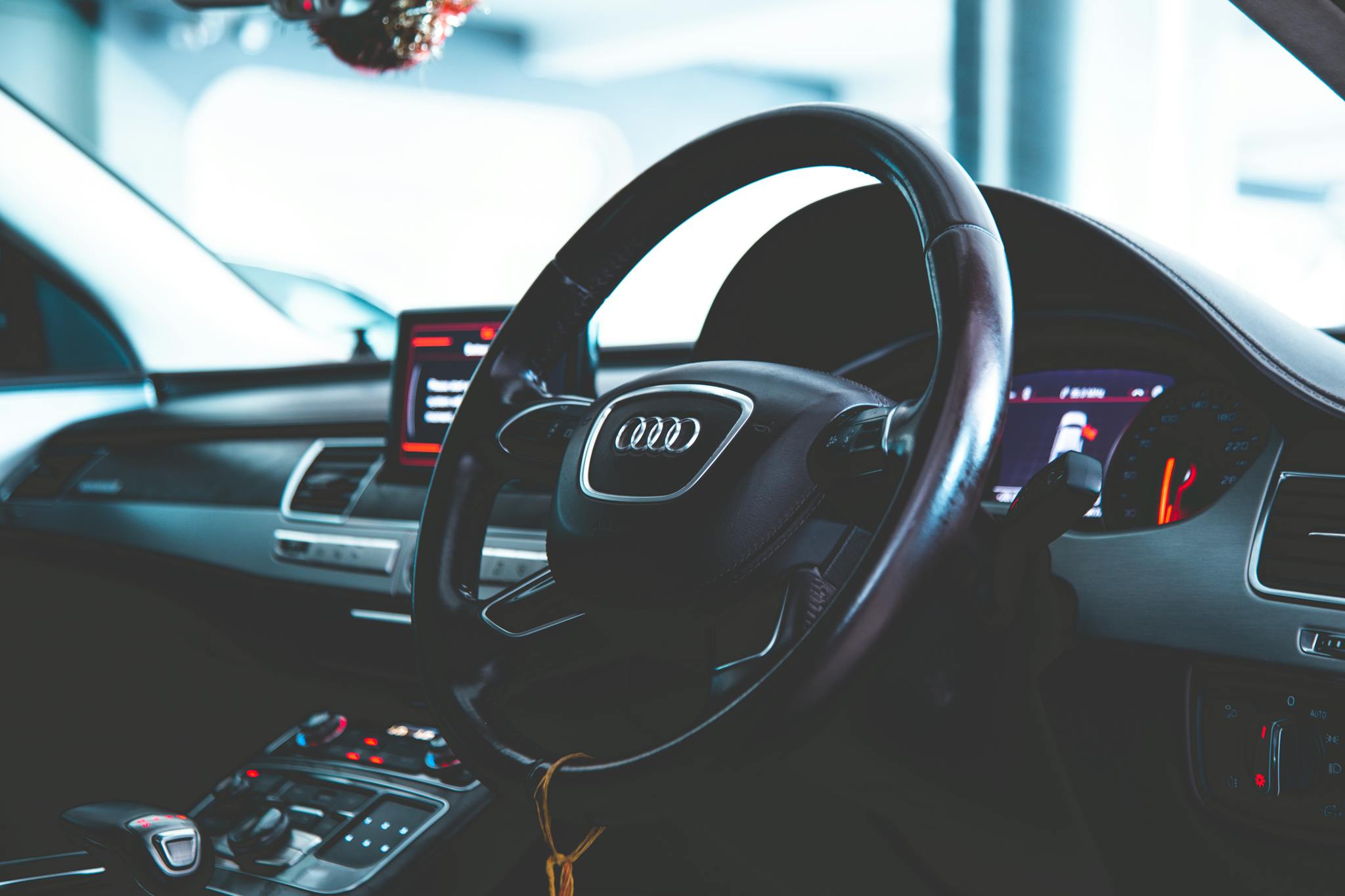 Close-up of a luxury car interior featuring the steering wheel and dashboard.
