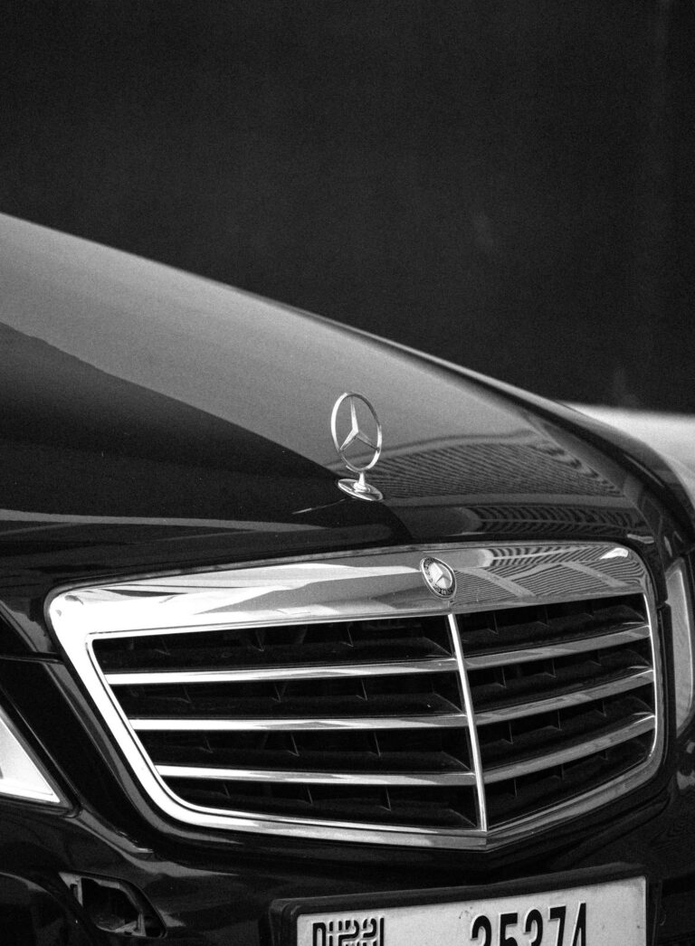 Black and white close-up of a Mercedes car grille and emblem with a luxury vibe.
